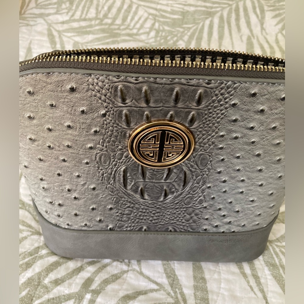 Like new, gray purse with gold details on the front.